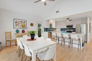 a kitchen and dining room with a white table and chairs at Redbird Retreat On Lake Travis in Marble Falls