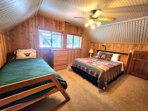 a bedroom with a bed and a ceiling fan at Toste Cabin- Spacious 3br Cabin In East Village! in Shaver Lake