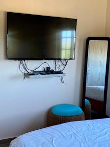 a flat screen tv hanging on a wall next to a bed at Cozy Apartment a 2 minutes to the Marriott in Noord