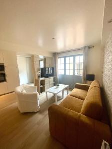 a living room with a couch and a table at Charmant logement rénové dans l’hyper centre in Auxerre