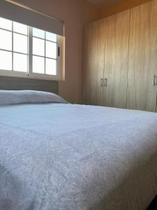 Schlafzimmer mit einem großen weißen Bett und Holzschränken in der Unterkunft Cozy Apartment a 2 minutes to the Marriott in Noord