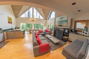 a large living room with couches and a kitchen at Pinnacle Ridge 05 - Ski In Ski Out, Private Hot Tub, Gas Fireplace in Whistler