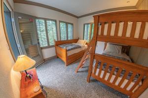 a bedroom with two bunk beds and a lamp at Pinnacle Ridge 05 - Ski In Ski Out, Private Hot Tub, Gas Fireplace in Whistler