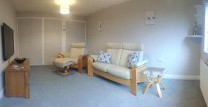 een woonkamer met een bank en een tafel bij The Annex Roundaway Lodge in Okehampton