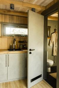 an open door in a kitchen with a sink at Jungle SPA bungalows in Žocenes Ciems