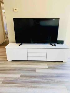 a large flat screen tv sitting on a white entertainment center at Beautiful home near Disneyland. Entire place! in Orange