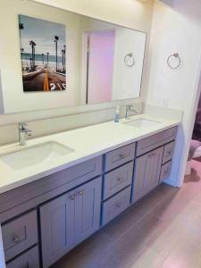 a bathroom with two sinks and a large mirror at Beautiful home near Disneyland. Entire place! in Orange