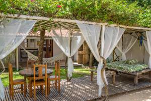 a pergola with a bed and a table and chairs at casa jasmin in Jericoacoara