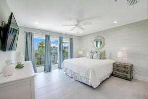 a white bedroom with a bed and a balcony at Ocean Overlook in Siesta Key +46 photos