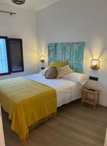 een slaapkamer met twee bedden met blauwe hoofdeinden en een tafel bij Casa La Zurita in Tabernas