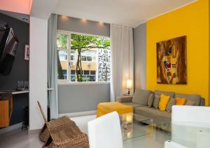 sala de estar con sofá y ventana en Leblon Dream Apartment, en Río de Janeiro