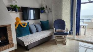 ein Wohnzimmer mit einem Sofa und einem Stuhl in der Unterkunft ELENA flat A little paradise right on the BEACH in Sitio de Calahonda