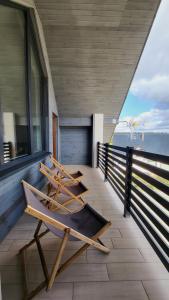 two chairs on a balcony with a view of the ocean at Hotel Konopielka in Zblewo