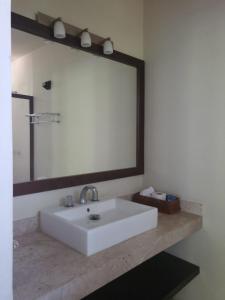 a bathroom with a white sink and a large mirror at Hotel Azul Esmeralda in Teapa