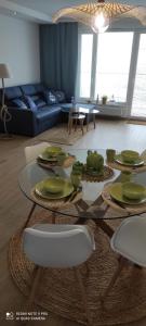 a living room with a table with green dishes on it at Apartament Baltic Sea -Przystań Letnica in Gdańsk