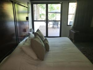 a bed with white sheets and pillows in a bedroom at Hotel Azul Esmeralda in Teapa