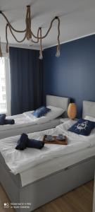 two beds in a room with blue walls at Apartament Baltic Sea -Przystań Letnica in Gdańsk