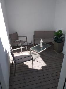un patio con 2 sillas, una mesa y un banco en La casa di May en Olbia