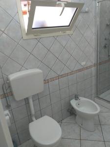 La salle de bains est pourvue de toilettes, d'un lavabo et d'une fenêtre. dans l'établissement La casa di May, à Olbia