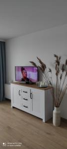 a tv sitting on top of a white cabinet at Apartament Baltic Sea -Przystań Letnica in Gdańsk