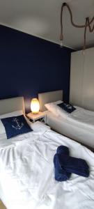 een slaapkamer met 2 bedden en een blauwe muur bij Apartament Baltic Sea -Przystań Letnica in Gdańsk