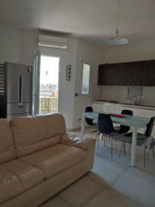 un soggiorno con un divano e un tavolo con sedie di A casa di Pato a Siracusa