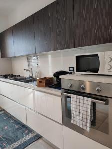 una cucina con fornelli e microonde di A casa di Pato a Siracusa