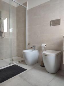 un bagno bianco con wc e doccia di A casa di Pato a Siracusa