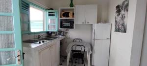 eine kleine Küche mit einem Kühlschrank und einem Stuhl darin in der Unterkunft DISTILLERIE in Tartane