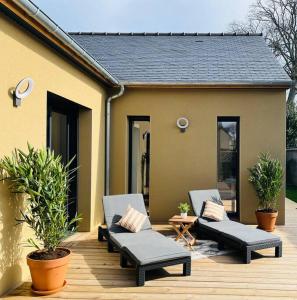 a deck with two lounge chairs and a house at Maison Terracotta vous accueille à 8min de Dinard in Le Minihic-sur-Rance