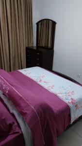 een paars bed met een dressoir in een slaapkamer bij harmony house 2 in Rabat