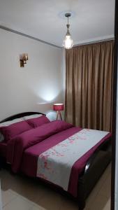 een slaapkamer met een groot bed met paarse lakens bij harmony house 2 in Rabat