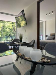 una sala de estar con una mesa con cuencos y sillas en Departamento ALTA Vista Pucon, en Pucón