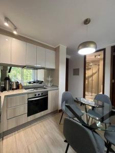 Una cocina y un comedor con mesa y sillas. en Departamento ALTA Vista Pucon, en Pucón