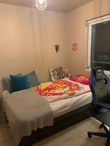 um pequeno quarto com uma cama e uma cadeira em Beautiful apartment near Airport em Njarðvík