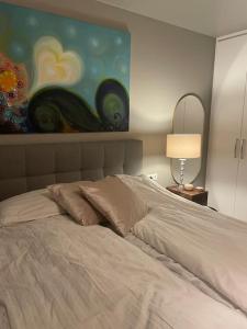 1 dormitorio con 1 cama con una pintura en la pared en Beautiful apartment near Airport, en Njarðvík