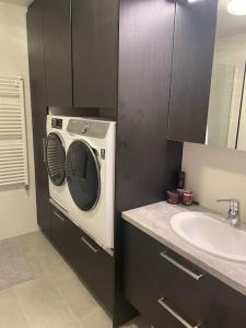 a bathroom with a washing machine and a sink at Beautiful apartment near Airport in Njarðvík