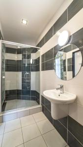 La salle de bains est pourvue d'un lavabo et d'une douche. dans l'établissement Hotel & Cafe SokoLOVE, à Sokolov