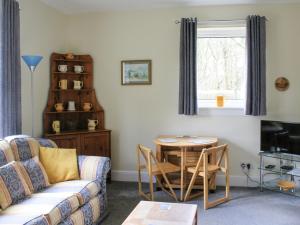 - un salon avec un canapé et une table dans l'établissement Riversdale Cottage, à St Fillans