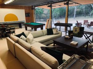 a living room with couches and a pool table at The Camp Blanco by Lodgewell - Riverfront retreat 2 Homes, Bunk House, Game Room & more in Blanco