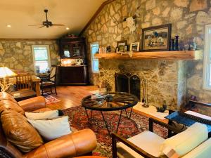 a living room with a couch and a fireplace at The Camp Blanco by Lodgewell - Riverfront retreat 2 Homes, Bunk House, Game Room & more in Blanco