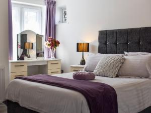 a bedroom with a large bed and a mirror at Blue Haven in Westward Ho