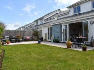 a backyard of a house with a patio with a table at Blue Haven in Westward Ho