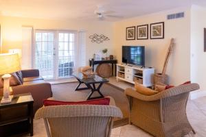uma sala de estar com um sofá e uma televisão em Royal Palm #1B em Siesta Key