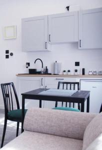 a kitchen with a table and chairs and a sink at Apartament z historią in Jelenia Góra