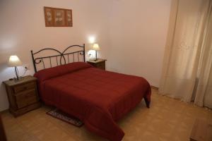 a bedroom with a red bed and two night stands at Apartamento Paco entre Valencia y Castellón in Benafer