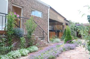 a garden in front of a brick building with flowers at Guest House Fairy Tale in Kaji-Say