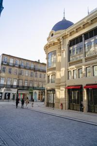 un edificio en una calle con gente caminando delante de él en Bolhão Studio, Porto, en Oporto