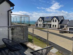 a balcony with two chairs and a view of houses at Galwad y Mor in Haverfordwest
