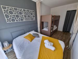 a bedroom with a bed with towels on it at La Cabane aux Ecureuils Appart à 500m de la plage Forêt in Mimizan